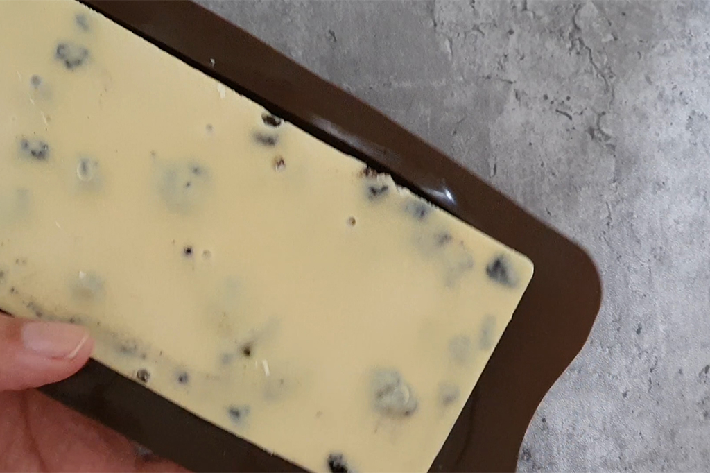 Chocolat blanc fondu versé dans le moule à tablette