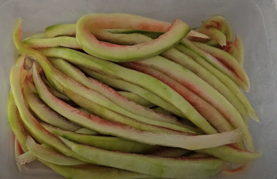 Bonbons faits maison avec la peau de pastèque, colorés en rouge, vert et bleu et enrobés de sucre