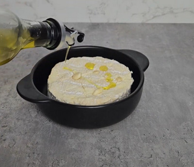 Camembert quadrillé et piqué d'ail prêt à enfourner
