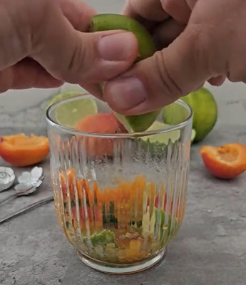 Abricots, citron vert et menthe écrasés au pilon au fond du verre