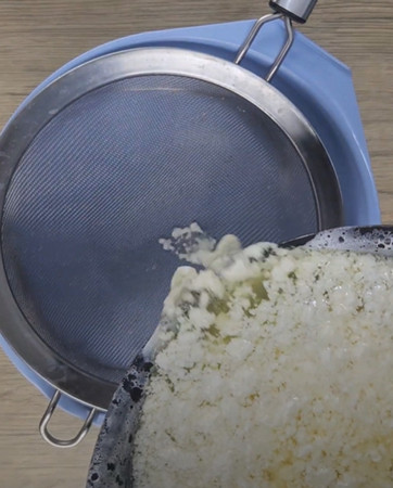 Lait caillé égoutté dans une étamine pour faire du fromage frais maison