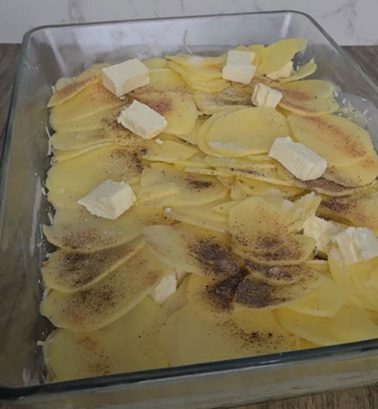 Couches de pommes de terre, beurre et beaufort dans le plat