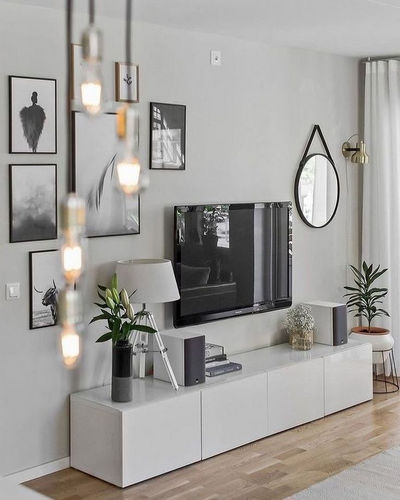 Téléviseur fixé au mur au-dessus d'un meuble TV fin