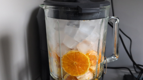 Chair d'orange, glaçons et miel dans un blender