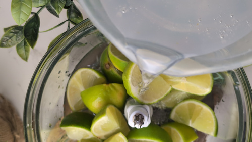 Citrons verts en quartiers mixés avec de l'eau